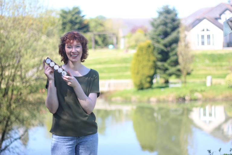 Lady holding candles in front of lake